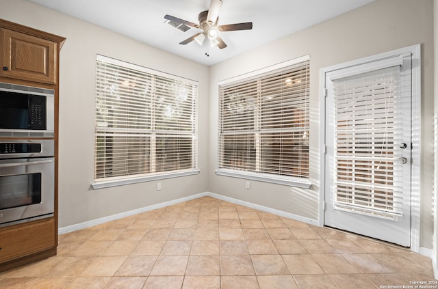 kitchen with light tile patterned flooring, ceiling fan, and appliances with stainless steel finishes