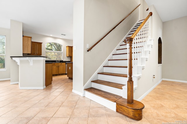 staircase featuring tile patterned flooring and sink