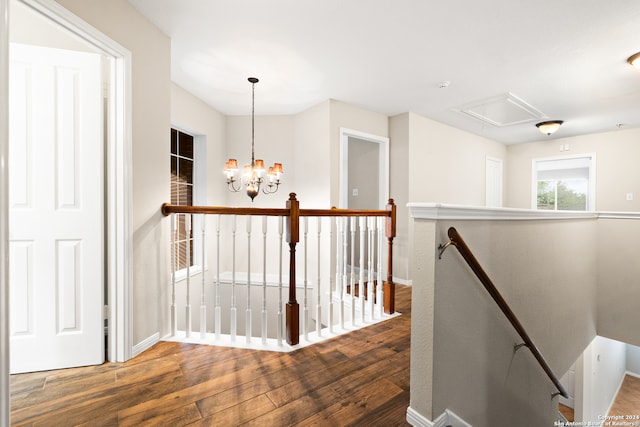 hallway with wood-type flooring and a chandelier