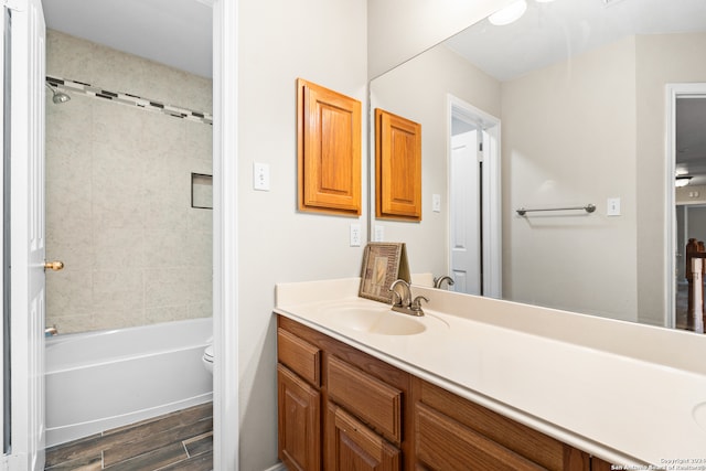 full bathroom featuring vanity, hardwood / wood-style flooring, toilet, and tiled shower / bath