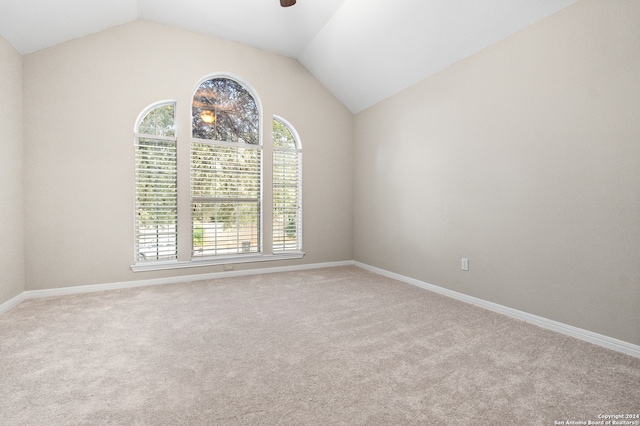 unfurnished room with ceiling fan, lofted ceiling, light carpet, and a healthy amount of sunlight