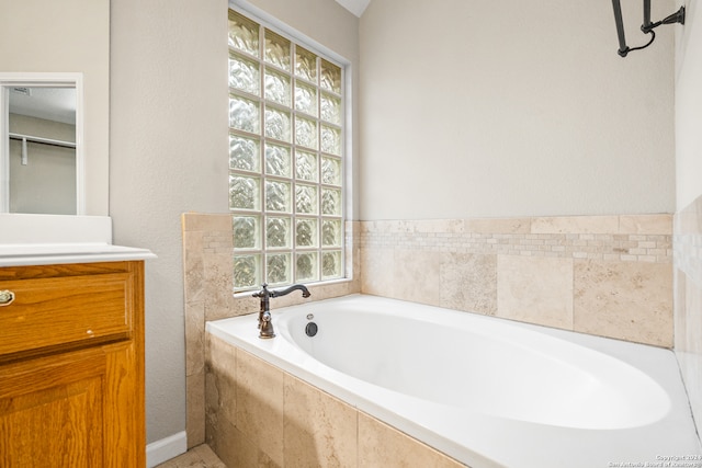 bathroom featuring vanity and tiled tub