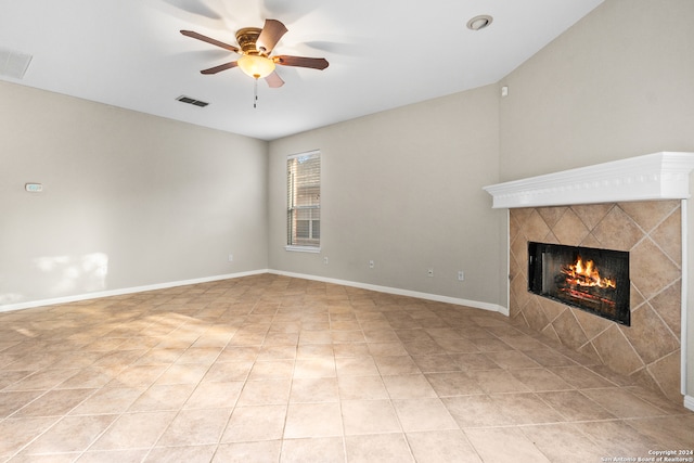 unfurnished living room featuring a tiled fireplace, light tile patterned floors, and ceiling fan