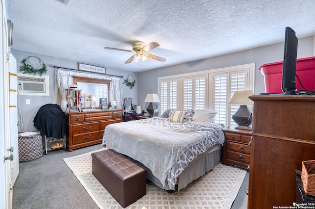 bedroom featuring a textured ceiling, light carpet, ceiling fan, and a wall mounted AC