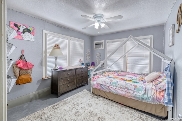 bedroom featuring a wall unit AC, ceiling fan, and a textured ceiling