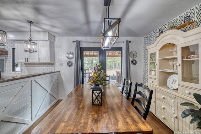 dining space featuring dark hardwood / wood-style flooring, a wealth of natural light, and a chandelier