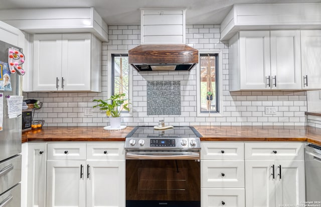 kitchen with butcher block counters, a healthy amount of sunlight, decorative backsplash, and stainless steel appliances