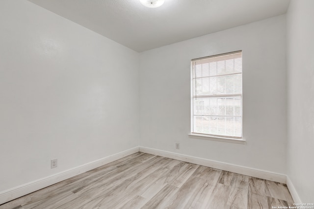 spare room featuring light hardwood / wood-style floors and plenty of natural light