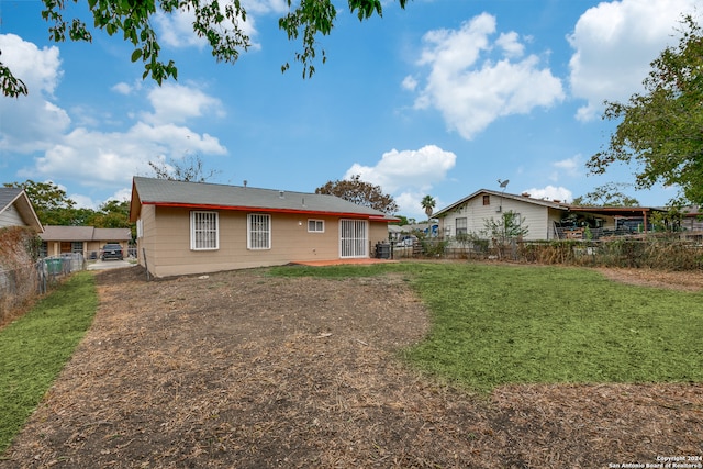 rear view of property featuring a yard