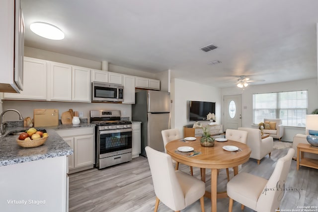 kitchen featuring light hardwood / wood-style floors, sink, ceiling fan, white cabinetry, and appliances with stainless steel finishes