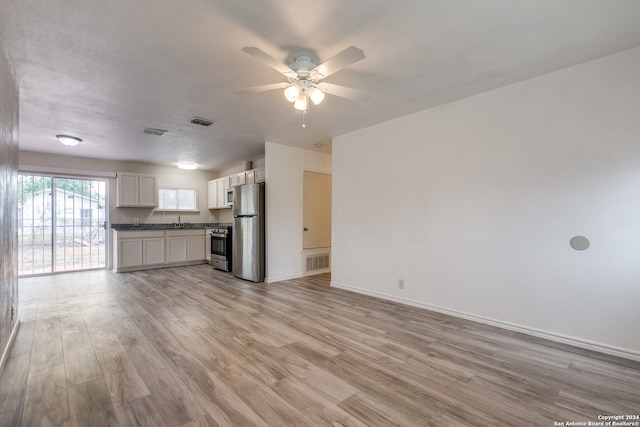 unfurnished living room with light hardwood / wood-style floors, ceiling fan, and sink