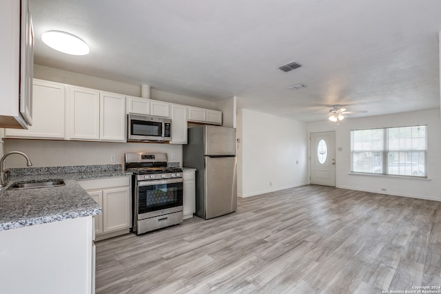 kitchen with white cabinetry, sink, appliances with stainless steel finishes, ceiling fan, and light wood-type flooring