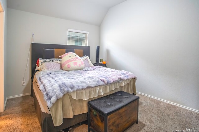 bedroom featuring lofted ceiling and carpet