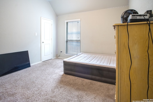 unfurnished bedroom featuring carpet and lofted ceiling