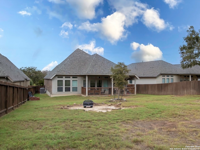 back of property with a yard and a fire pit