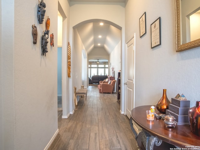 hall featuring lofted ceiling and hardwood / wood-style flooring