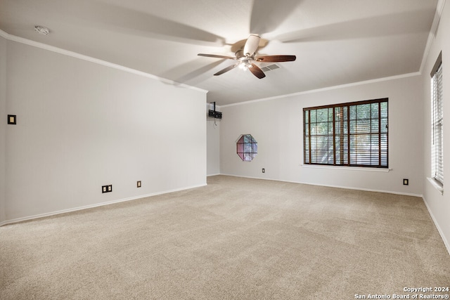 spare room featuring light colored carpet, ceiling fan, and crown molding