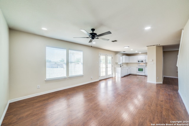 unfurnished living room featuring french doors, dark hardwood / wood-style floors, sink, and ceiling fan