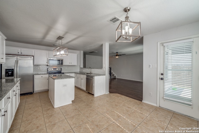 kitchen with white cabinetry, pendant lighting, a center island, and stainless steel appliances