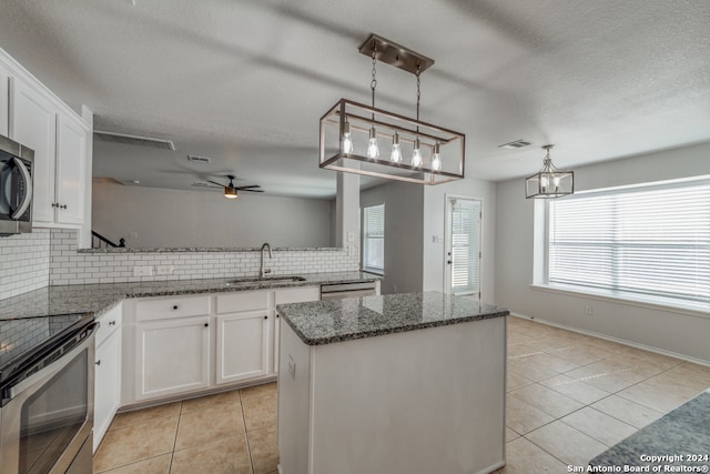 kitchen with tasteful backsplash, white cabinetry, and sink