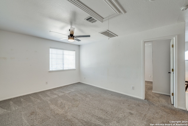 empty room with a textured ceiling, carpet floors, and ceiling fan