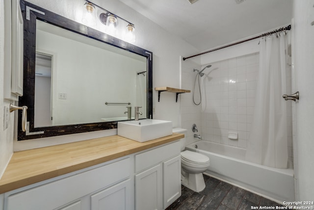 full bathroom featuring hardwood / wood-style floors, vanity, toilet, and shower / tub combo