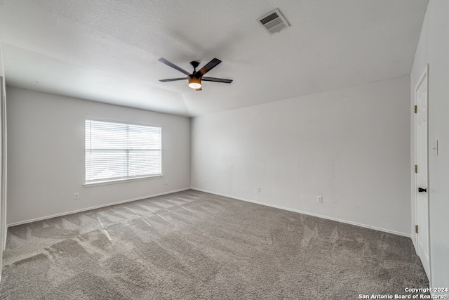 carpeted empty room with a textured ceiling, lofted ceiling, and ceiling fan