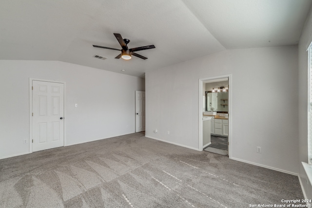 empty room with ceiling fan, light colored carpet, and vaulted ceiling