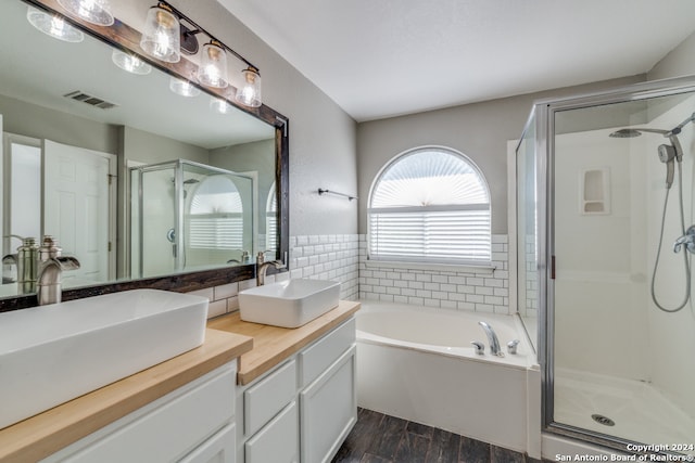 bathroom featuring hardwood / wood-style floors, vanity, and plus walk in shower