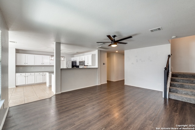 unfurnished living room with ceiling fan, wood-type flooring, and a textured ceiling