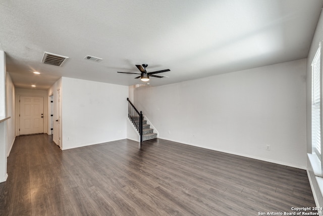 unfurnished living room with dark wood-type flooring, ceiling fan, and a textured ceiling