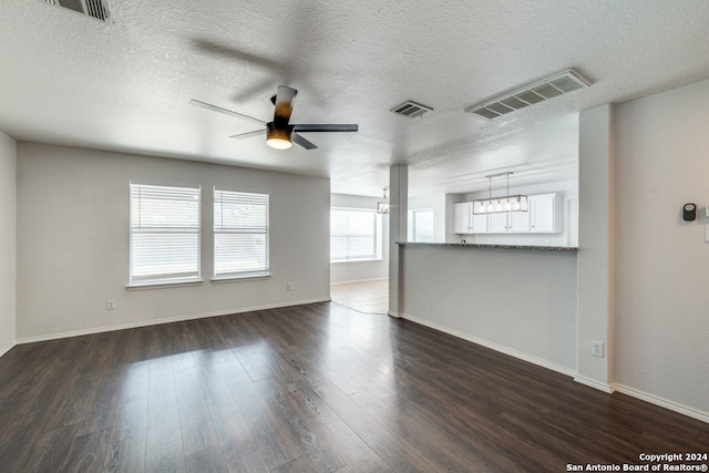 spare room with dark wood-type flooring, a textured ceiling, and ceiling fan