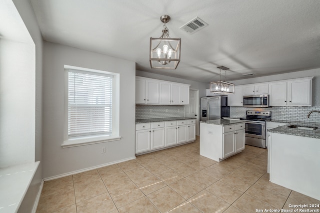 kitchen featuring pendant lighting, stainless steel appliances, sink, and a kitchen island