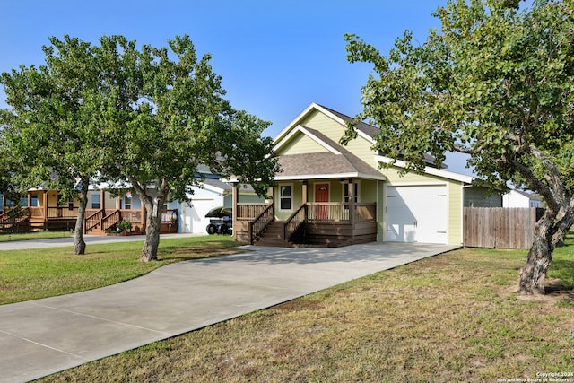 view of front of house with a front lawn, a garage, and covered porch