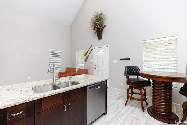 1403 S Young, Rockport, TX 78382 - kitchen with stainless steel dishwasher, a sink, high vaulted ceiling, light wood-type flooring, and light stone countertops
