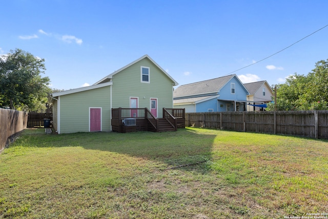 back of property featuring a lawn and a deck