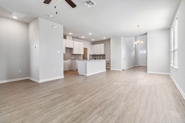 unfurnished living room with sink, light hardwood / wood-style floors, and ceiling fan with notable chandelier