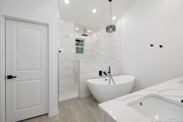 bathroom with vanity, shower with separate bathtub, and tile walls