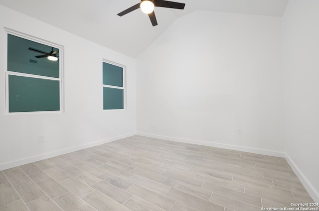 empty room featuring ceiling fan, light wood-type flooring, and lofted ceiling