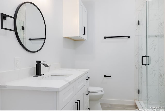 bathroom with toilet, an enclosed shower, and vanity