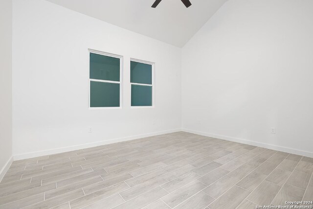 unfurnished room featuring ceiling fan, vaulted ceiling, and light hardwood / wood-style floors