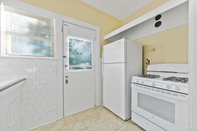 kitchen with white appliances and light tile patterned floors