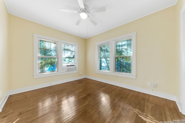 spare room featuring cooling unit, hardwood / wood-style flooring, and ceiling fan