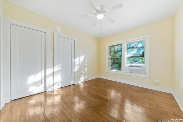 spare room featuring wood-type flooring, cooling unit, and ceiling fan