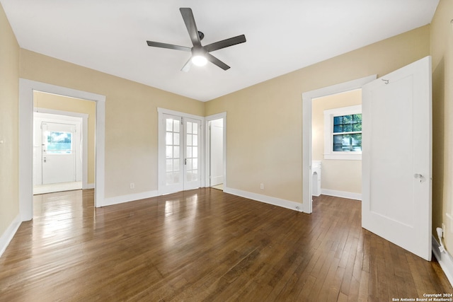 empty room featuring ceiling fan, dark hardwood / wood-style floors, and plenty of natural light