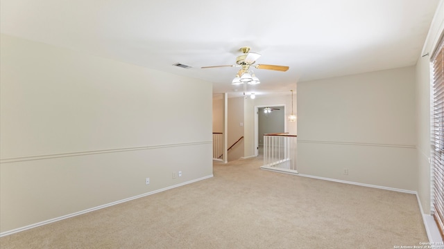 spare room with ceiling fan and light colored carpet