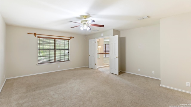 carpeted empty room featuring ceiling fan