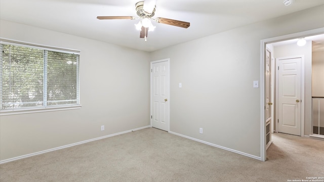 unfurnished room featuring light carpet and ceiling fan