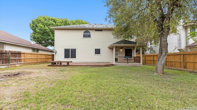 back of property featuring a yard and a deck