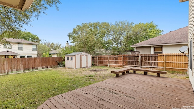 wooden terrace featuring a shed and a lawn